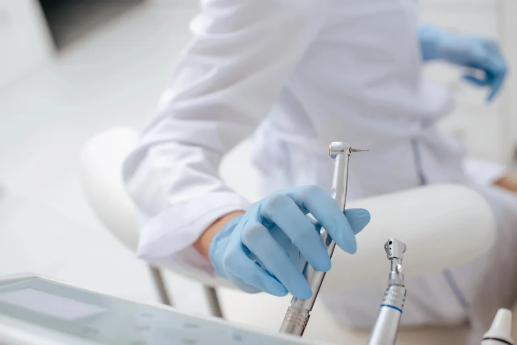 Unrecognized dentist in Pembroke Pines, holding instrument in room.