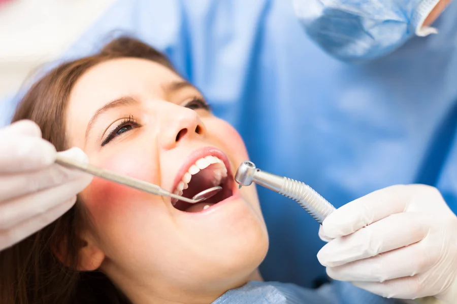 Patient getting teeth cleaning from a dentist on Hiatus Rd